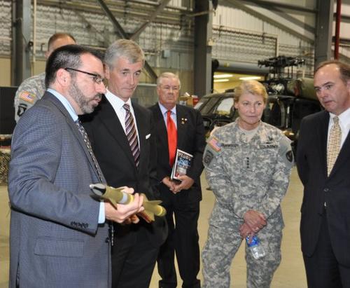 Bill Nourse, manager of the Extended Area Protection and Survivability Program, explains the concept behind an interceptor missile to John McHugh, secretary of the Army; John Rogers, civilian aide to the secretary of the Army; Gen. Ann Dunwoody, commander of Army Materiel Command; and Steve Cornelius, director for Missile Development, AMRDEC. Nourse holds in his hand the system's interceptor bullet, which is designed to be compact and lightweight.   (Source: Army)