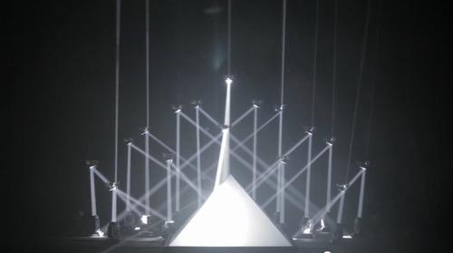 Flying in swarms and equipped with mirrors, 16 of the University of Pennsylvania's tiny flying quadrotor robots dazzled an audience at Cannes by manipulating sound and light and dancing to music. (Source: KMel Robotics)