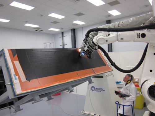 The first automated fiber placement machine in the UK, shown here with employee Tim Smith of GKN Aerospace, will help speed production of complex composite aircraft structures like wings.   (Source: National Composites Centre)