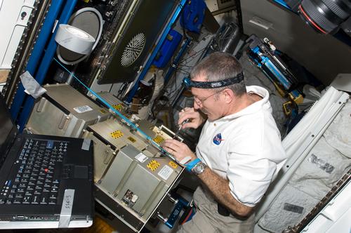 In one program for making replacement parts on the spot for the International Space Station, NASA is testing electron beam freeform fabrication This process, developed at NASA's Langley Research Center, makes metallic structures quickly using an electron beam gun and a dual-wire feed. It has been used to make titanium spars for the F-35 Joint Strike Fighter's vertical tails. NASA is tailoring hardware and processes to make it easier for astronauts such as Dan Burbank, Expedition 30 commander, to use. Burbank (shown here in the ISS Tranquility node) works on the atmosphere revitalization system's major constituent analyzer mass spectrometer assembly. (Source: NASA)