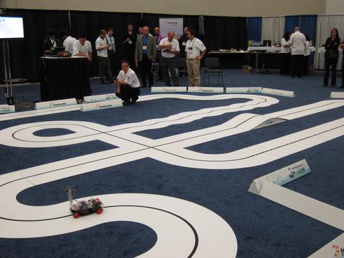 On the show floor, Freescale ran an autonomous vehicle competition called 'the Freescale Cup.' Model vehicles in the competition vied for fastest lap times by using onboard cameras to follow a line in the middle of the miniature roadway. The contest supplied vehicle chassis, rear-wheel drive motors, and powertrain controllers that incorporated Freescale's Qurivva microcontrollers. Competitors included GM, Ford, Chrysler, Continental, TRW, Bosch, Panasonic, Visteon, Aisin, and Johnson Controls.   (Source: Freescale Semiconductor) 