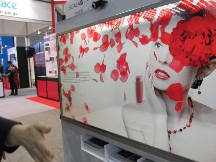 Digital signage specialist Ittocan demonstrated a transparent, interactive LCD display. Ittocan used Samsung's 46-inch transparent display combined with a Web camera connected to a set-top box running Windows Embedded. As a passerby waves his hand in front of the display window, rose petals superimposed on the transparent LCD screen disperse in response. 