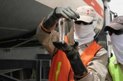Two international contractors inspect a sample of JP-8 fuel in Kuwait in 2010. The Army hopes to use the fuel as the basis for a 'super engine' that can power a number of ground and air vehicles, as well as generators using this fuel.   (Source: US Army Sgt. David Reardon, 1st Sustainment Brigade Public Affairs, US Army)