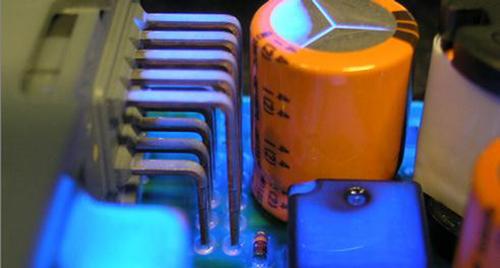 A silicone conformal coating has been spray-applied to automotive controllers, and fluoresces under UV light to aid visual inspection of the coating's coverage.   (Source: Dow Corning)

