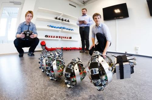 SINTEF researchers Pal Liljeback and Aksel Transeth, along with Knut Robert Fossum of NTNU's CIRiS, play with Wheeko the snake robot.(Source: SINTEF/Thor Nielsen)