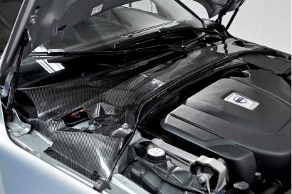 This shows an installed plenum cover created from the carbon fiber energy storage material developed by Volvo. It replaces three items in a standard car -- the rally bar, traditional plenum cover and the start-stop battery -- and saves more than 50 percent of system weight. (See full size image.)(Source: Volvo Car Group)