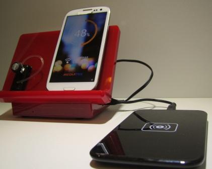 Left (in red) shows a wireless charging station based on resonant power transfer technology. Right is Qi wireless charging station using industive power transfer technology. (Source: EE Times/Junko Yoshida)