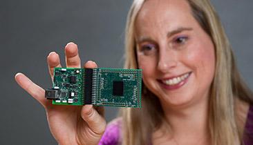 Professor Hasler holds an FPAA board she is using to emulate biologically based neural networks. (Source: Rob Felt courtesy of Georgia Tech)
