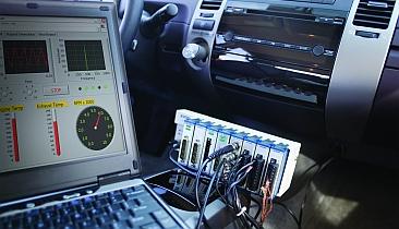 Test hardware can operate in a vehicle by measuring data from sensors and communicating with automotive electronic systems.
