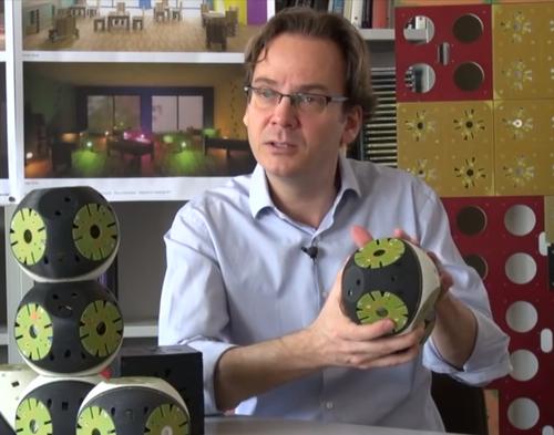 EPFL head of its Biorobotics Laboratory, Auke Ijspeert, shows the mobile Roombot, which fits together with other pieces to make adaptive furniture.
(Source: EPFL)