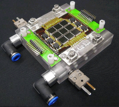 A small prototype of the IBM cooling manifold extracting the heat from the nine multi-junction solar cells in the center.
(Source: IBM)