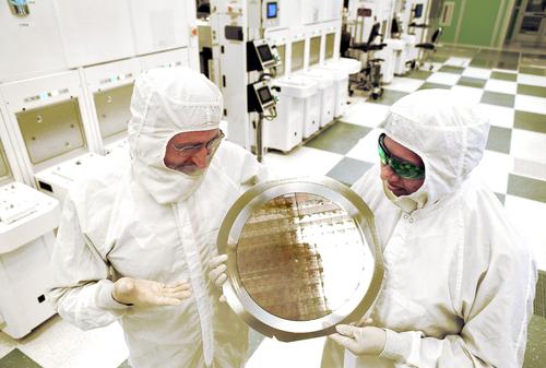 Professor Michael Liehr (left) of SUNY Polytechnic Institute's Colleges of Nanoscale Science and Engineering (SUNY Poly CNSE) and Bala Haran (right) of IBM Research inspect 7-nanometer wafer of test chips developed in alliance partnership between IBM and SUNY Poly CNSE.
(Source: Darryl Bautista/Feature Photo Service for IBM)