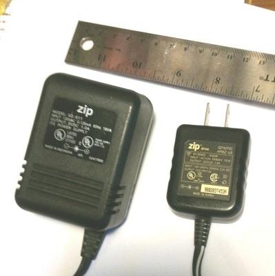 The supplied Iomega ZIP drive linear converter (left) and the replacement switching converter (right) both produce a 5 V/1 A DC output, but with very different weight and size.