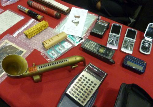 A QRS Playsax from the 1930s uses a paper roller to play music. Next to it is a TI-30 calculator, introduced in 1976.