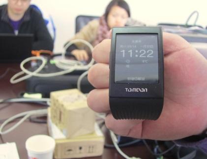 ToMoon's smartwatch, with ToMoon design engineers in the background on site at Ingenic